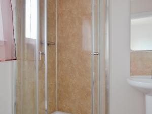 prysznic ze szklanymi drzwiami obok umywalki w obiekcie Ard Meanish w mieście Milovaig