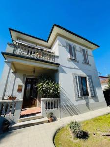 een wit huis met een veranda en een balkon bij Primo piano villa liberty indipendente a Lucca in Lucca