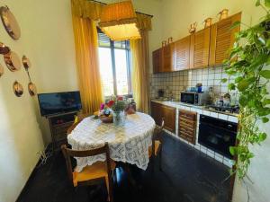 een keuken met een tafel met stoelen en een raam bij Primo piano villa liberty indipendente a Lucca in Lucca