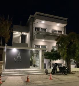 Biały dom z motocyklem zaparkowanym przed nim w obiekcie Alkyonides Boutique Hotel w mieście Kremasti
