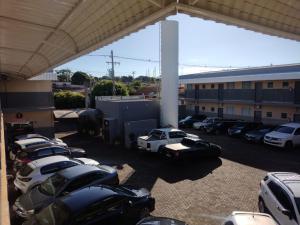 eine Gruppe von Autos, die auf einem Parkplatz geparkt sind in der Unterkunft Glória Hotel in Olímpia