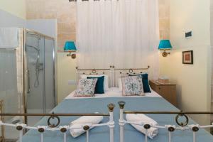 a bedroom with a bed and a glass shower at Casa Ricca in St Paul's Bay