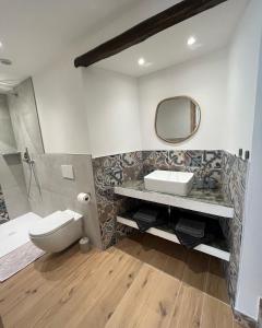 ein Badezimmer mit einem WC, einem Waschbecken und einem Spiegel in der Unterkunft Wowies room in Pettenasco