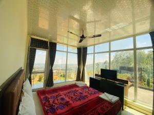 a bedroom with a bed and a large window at Tulips Valley View Resorts in Ooty