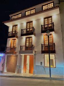 a large white building with balconies and a street light at Hotel Silva Inn in Cajamarca