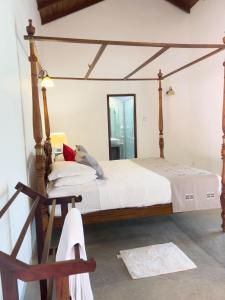 a bedroom with a canopy bed and a mirror at Coco Mantra Ilukwehera Estate 