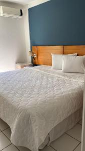 ein Schlafzimmer mit einem großen weißen Bett und einer blauen Wand in der Unterkunft Apart_Hotel Ponta negra in Natal