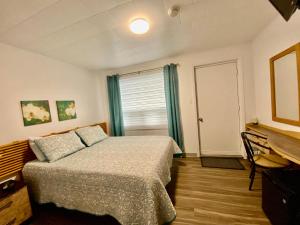 - une chambre avec un lit, un bureau et une fenêtre dans l'établissement L`Escale Lam-Air, à Rivière-au-Tonnerre