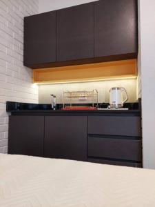a kitchen with black cabinets and a counter top at Hermoso y elegante monoambiente in Cochabamba