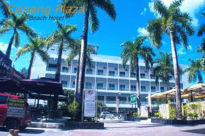 hotel przy plaży z palmami przed nim w obiekcie Cenang Plaza Beach Hotel w mieście Pantai Cenang