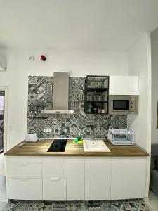 uma cozinha com armários brancos e uma bancada em El Mosaico Apartment em Valência
