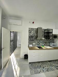 uma cozinha com armários brancos e piso em azulejo em El Mosaico Apartment em Valência