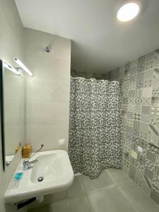 a bathroom with a sink and a shower curtain at El Mosaico Apartment in Valencia
