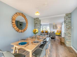 a dining room with a table and chairs and a mirror at Trewethett Farm in Forrabury