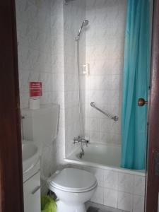 a bathroom with a toilet and a shower with a blue shower curtain at Canadian Star in Praia de Mira