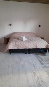 a bed in a bedroom with a wooden floor at Lujan Homes in Luján