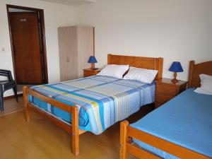プライア・デ・ミラにあるCanadian Starのベッドルーム1室(ベッド2台、椅子、ランプ付)