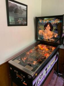 une machine de jeux vidéo avec une photo sur le mur dans l'établissement Harte's Desire Cabin - Lake, A/C, Arcade +, à Twain Harte