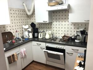 uma cozinha com armários brancos e um forno com placa de fogão em Unterkunft zu Krone em Hofheim in Unterfranken
