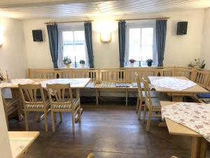 uma sala de jantar com mesas, cadeiras e janelas em Unterkunft zu Krone em Hofheim in Unterfranken