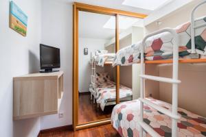 a small room with bunk beds and a mirror at Dúplex Surf junto a la playa in Miengo