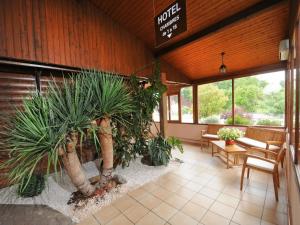 eine Lobby mit Topfpflanzen in einem Gebäude in der Unterkunft Hotel La Cabane in Belin-Beliet