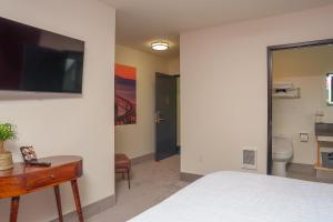 a bedroom with a bed and a tv on a wall at The Inn at 515 15th in Astoria, Oregon