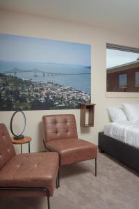 a bedroom with a bed and a chair and a large window at The Inn at 515 15th in Astoria, Oregon