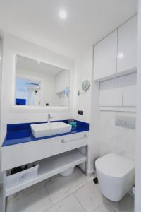 a white bathroom with a toilet and a sink at ORBI CITY APART HOTEl in Batumi