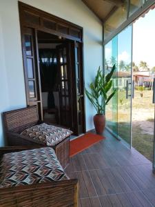 a porch with a bench and a potted plant at Bangalô Panorâmica in Conde