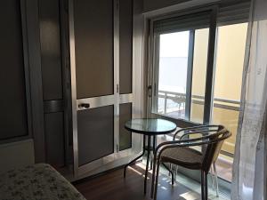 プライア・デ・ミラにあるCanadian Starの窓付きの客室で、小さなテーブルと椅子が備わります。