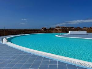una gran piscina azul en la parte superior de un edificio en AliNico House Majanicho iRent Fuerteventura, en La Oliva