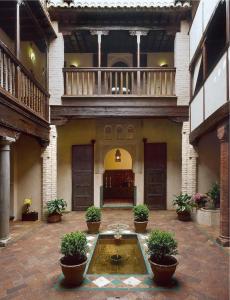 einen Innenhof mit einem Brunnen in der Mitte eines Gebäudes in der Unterkunft Hotel Casa Morisca in Granada