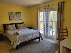 um quarto com uma cama e uma grande janela em Preston Hollow em Bloomington