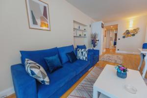 巴統的住宿－ORBI CITY APART HOTEl，客厅配有蓝色的沙发和白色的桌子