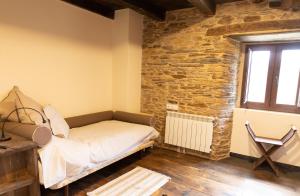 Habitación con cama y pared de piedra. en CASA GRANDE VILAR, en Vilar