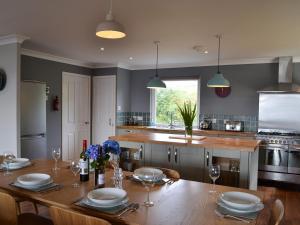 a kitchen with a wooden table with plates and wine glasses at Morlich in Gairloch