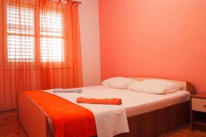 - une chambre avec un lit recouvert d'une couverture orange dans l'établissement Comfortable Apartment 6+2, à Makarska