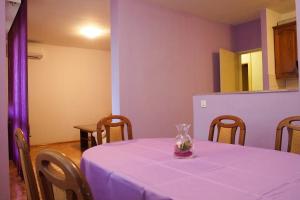 une table avec un chiffon de table violet et un vase dessus dans l'établissement Comfortable Apartment 6+2, à Makarska