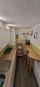 a kitchen with a counter and a wooden table at Ferienwohnung Bergblick in Sebnitz