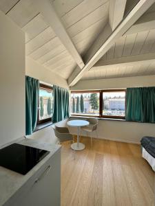 a living room with a table and some windows at C House Rooms Lake in Peschiera del Garda