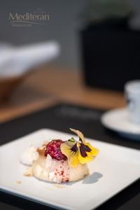 a white plate with a dessert with a flower on it at Hotel Mediteran in Zadar