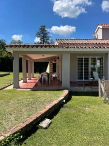 een huis met een overdekte veranda en een patio bij La Elina in Villa General Belgrano