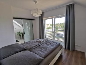 ein Schlafzimmer mit einem großen Bett und einem großen Fenster in der Unterkunft Sworny-Apartments in Swornegacie