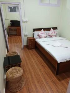 a bedroom with a bed with pink pillows on it at Primrose Homestay in Darjeeling