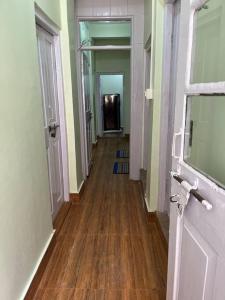 un couloir d'une pièce vide avec du parquet dans l'établissement Primrose Homestay (A cozy 2 bedroom apartment), à Darjeeling