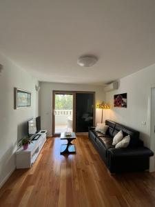 a living room with a black couch and a table at Apartman Ambasador in Makarska