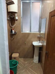 Elle comprend une petite salle de bains pourvue d'un lavabo et d'une fenêtre. dans l'établissement Primrose Homestay (A cozy 2 bedroom apartment), à Darjeeling
