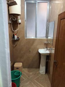 a small bathroom with a sink and a window at Primrose Homestay in Darjeeling +4 photos