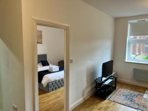 a bedroom with a mirror with a bed and a television at Quiet, Private and Serene in Southend-on-Sea